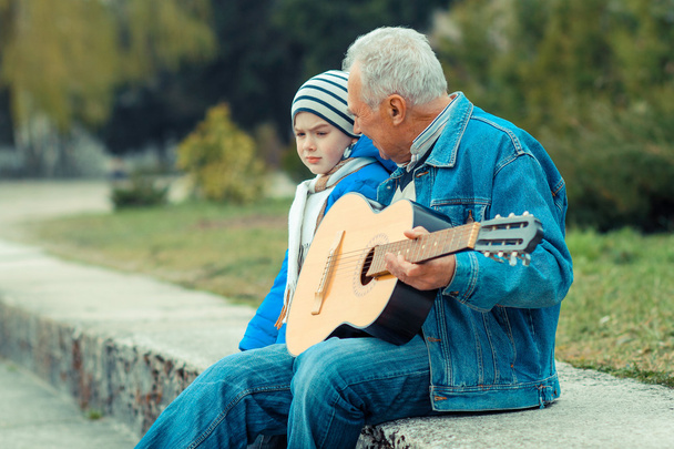 Grand-père et petit-fils jouant de la guitare
 - Photo, image