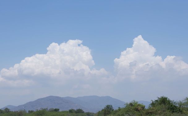 Blauwe hemelachtergrond met wolken boven de berg - Foto, afbeelding