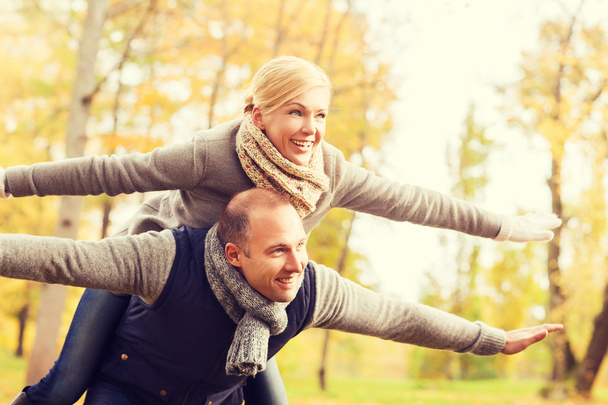 Lächelndes Paar amüsiert sich im Herbstpark - Foto, Bild