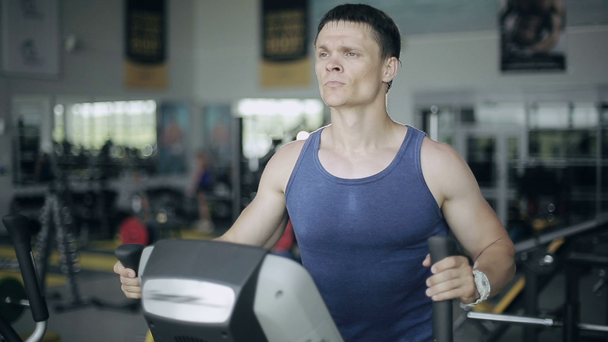 gutaussehender Mann im Fitnessstudio, der auf dem Siebgerät trainiert. links 3 / 4 Gesicht Portrait - Filmmaterial, Video
