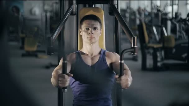 Muscular bodybuilder doing exercises workout in gym for breast muscles. Full face shot - Video, Çekim