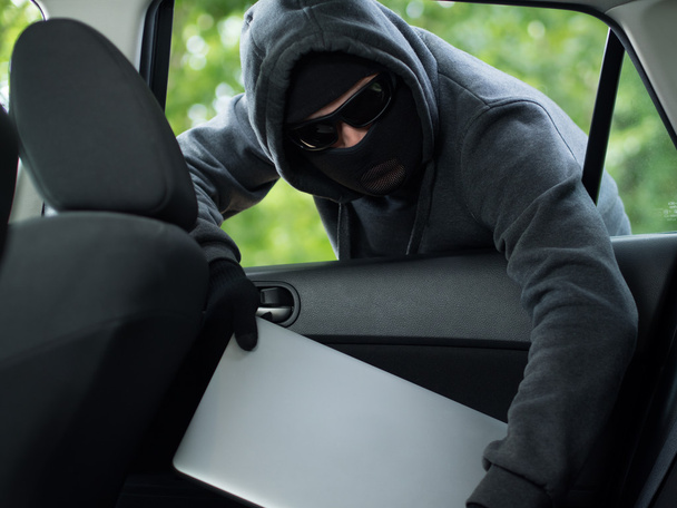 Car theft - a laptop being stolen through the window of an unoccupied car. - Фото, изображение
