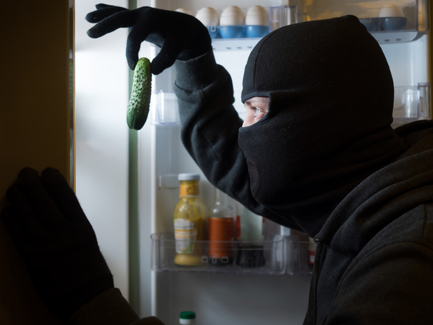 Thief. Man in black mask with a cucumber. - Foto, Bild