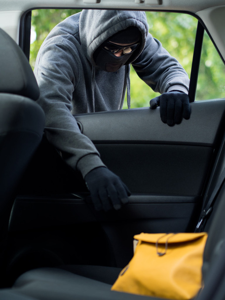 Transportation crime concept .Thief stealing bag from the car - Foto, Imagem