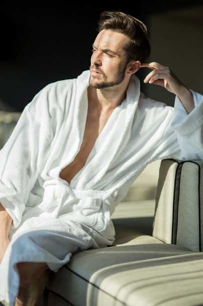 healthy male in a robe relaxing on a couch - Photo, Image