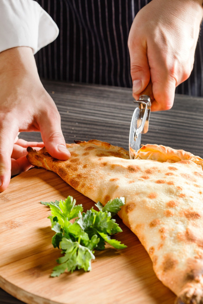 man cutting pizza - Foto, afbeelding