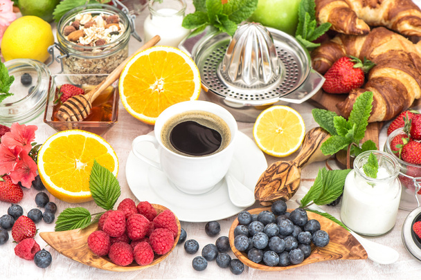 Breakfast table setting with coffee, croissants, muesli, honey.  - Foto, immagini