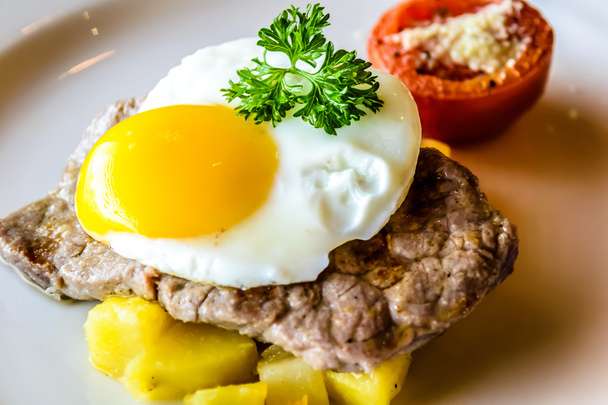 Стейк из серлуина с жареным яйцом и картошкой на завтрак
 - Фото, изображение