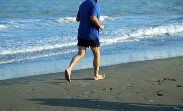 formda kalmak için deniz sahilde yetişkin atlet çalışır - Fotoğraf, Görsel