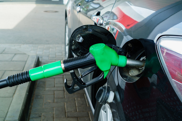 Car refueling on a petrol station. Focus on filling nozzles - Photo, Image