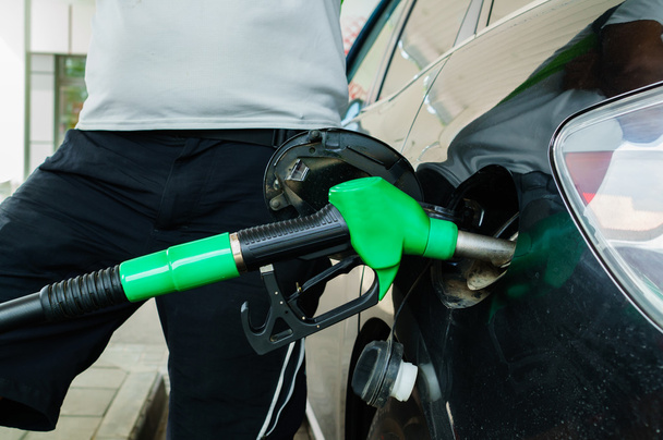 El hombre llena su auto con gasolina en la gasolinera
 - Foto, Imagen