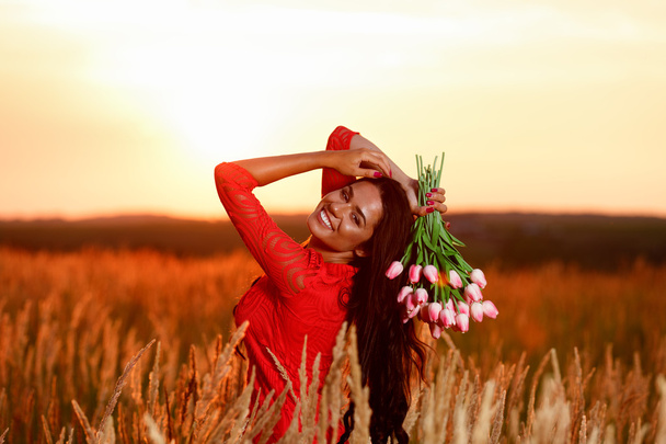 a keze tulipán piros ruha gyönyörű barna nő egy  - Fotó, kép
