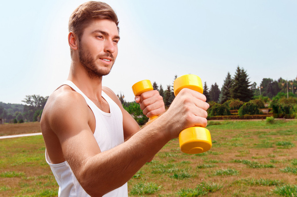 Pleasant guy holding weights  - Foto, immagini