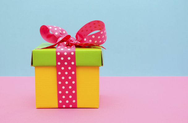Φωτεινό κουτί δώρου σε ροζ και μπλε φόντο.  - Φωτογραφία, εικόνα