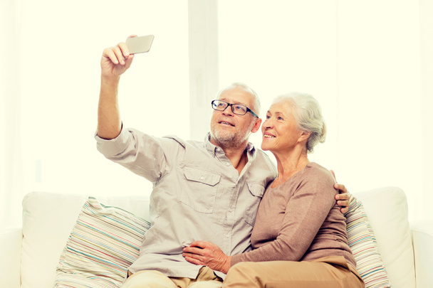 happy senior couple with smartphone at home - Foto, afbeelding