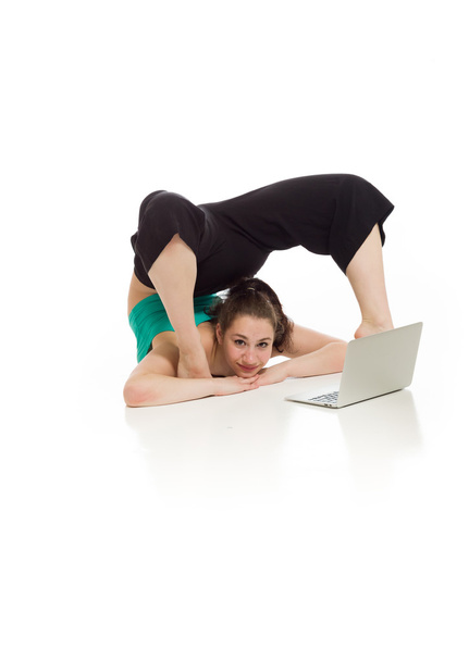 Gymnastic Model stretching with laptop - Foto, afbeelding