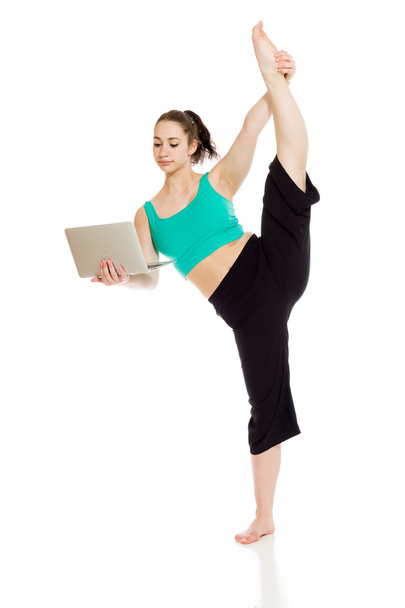 Γυμναστικός μοντέλο τέντωμα με laptop - Φωτογραφία, εικόνα