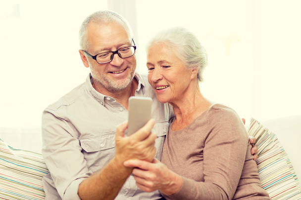 happy senior couple with smartphone at home - Фото, зображення