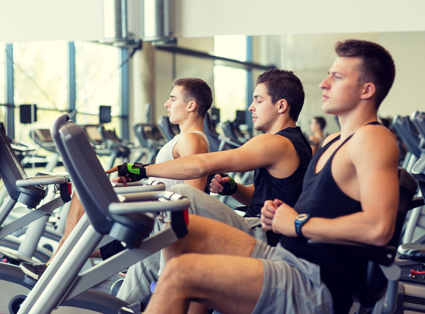 men working out on exercise bike in gym - Photo, Image