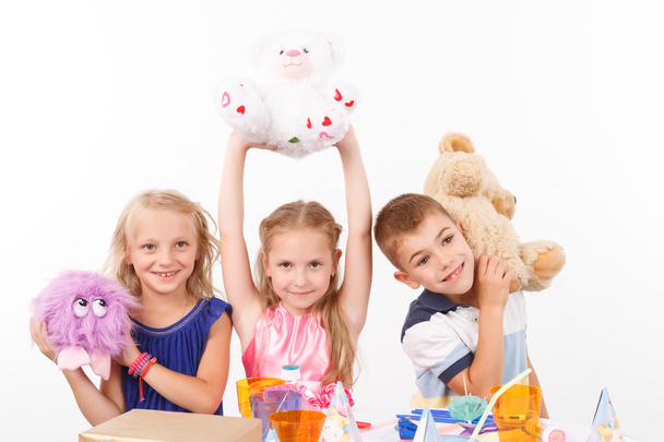 Crianças sorridentes segurando brinquedos macios
 - Foto, Imagem
