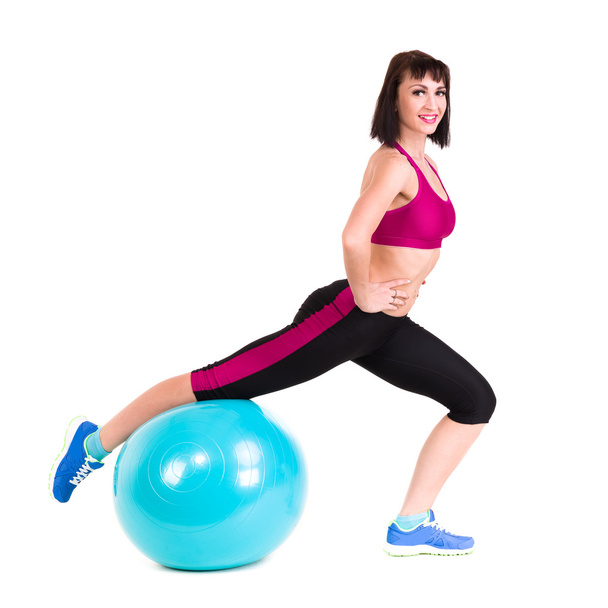 Young smiling woman makes exercise with fitball - 写真・画像