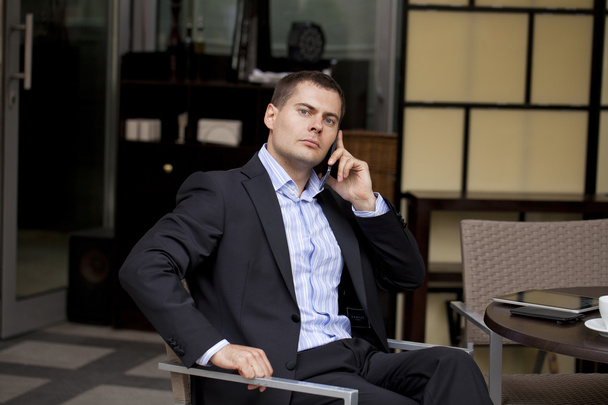 Cheerful young businessman calling by phone - Foto, afbeelding