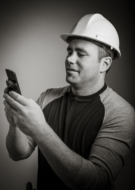 Hombre con casco protector usando teléfono móvil
 - Foto, Imagen