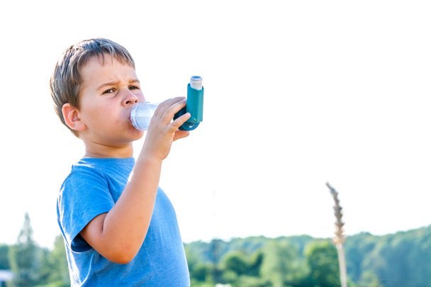 Fiú segítségével inhaláló, az asztma, a falu nyári naplementében - Fotó, kép