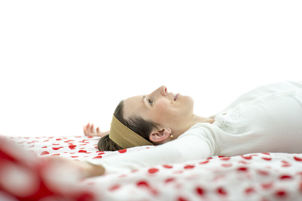 Jeune femme portant un bandeau couché sur un lit
 - Photo, image