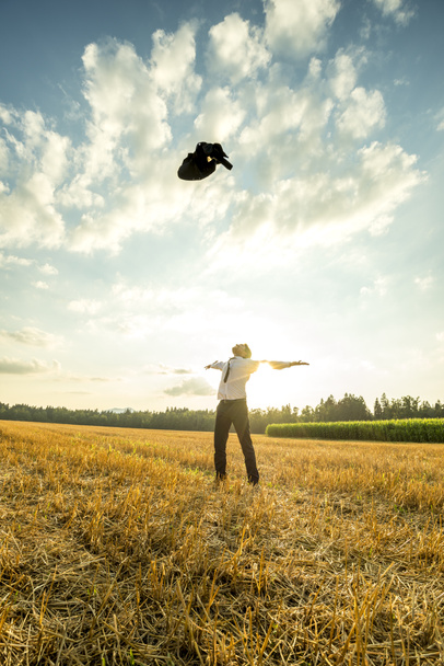 Успішний молодий чоловік кидає пальто в повітря
 - Фото, зображення