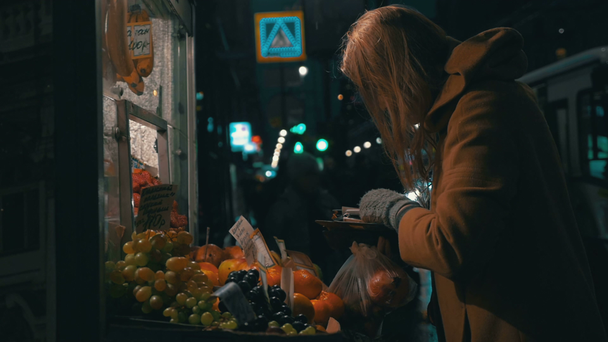 Женщина покупает фрукты в уличной кабинке
 - Кадры, видео