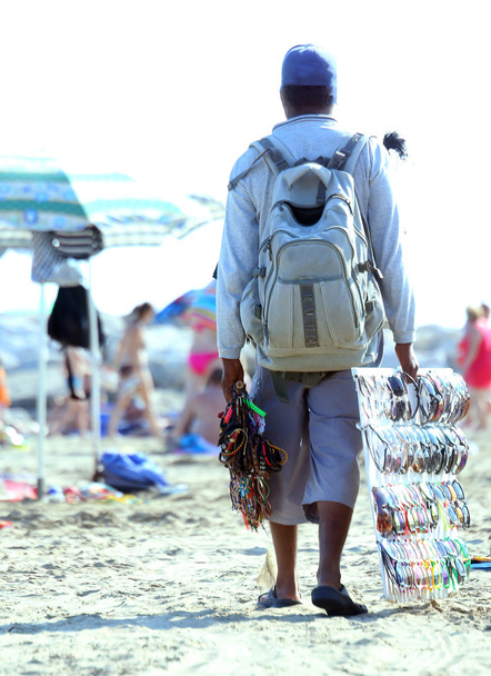 夏のビーチでネックレスとサングラスの行商人 - 写真・画像