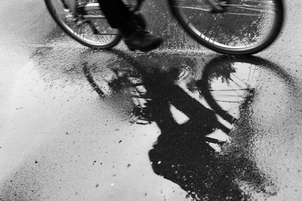 Radfahrer spiegelt sich in Pfütze - Foto, Bild
