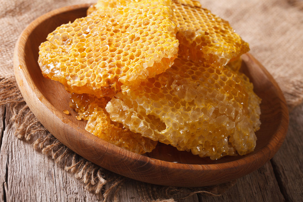 Свежий мед расчески на деревянной тарелке крупным планом. hhhontal
  - Фото, изображение