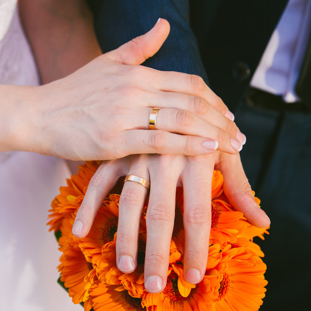 Руки жениха и невесты с обручальными кольцами на пальцах
 - Фото, изображение