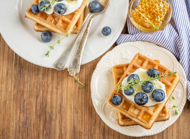 Homemade fresh crispy waffles for breakfast with blueberries and honey - Valokuva, kuva