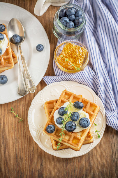 hausgemachte frische, knusprige Waffeln zum Frühstück mit Blaubeeren und Honig - Foto, Bild