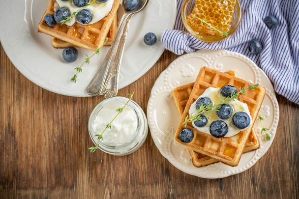 Homemade fresh crispy waffles for breakfast with blueberries and honey - Foto, afbeelding