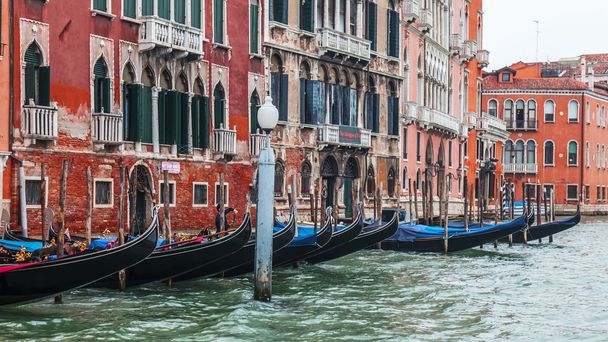 VENICE, ITALY - on MAY 4, 2015. Gondolas are moored about the coast of the channel. Ancient palaces on the embankment - 写真・画像