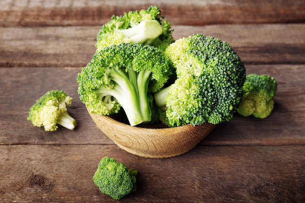 Fresh broccoli in bowl on wooden table close up - Zdjęcie, obraz