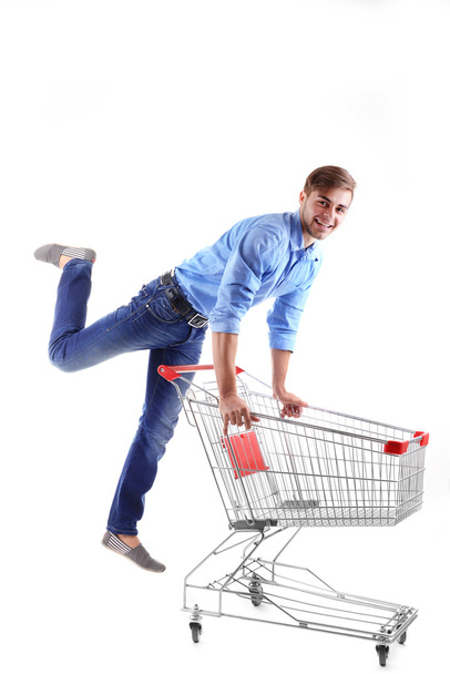 Young man with empty shopping cart, isolated on white - Foto, Bild