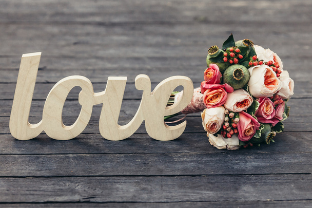 The word love with beautifull wedding bouquet on wooden backgrou - Zdjęcie, obraz