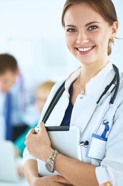 Attractive female doctor  with folder in front of medical group - Фото, зображення