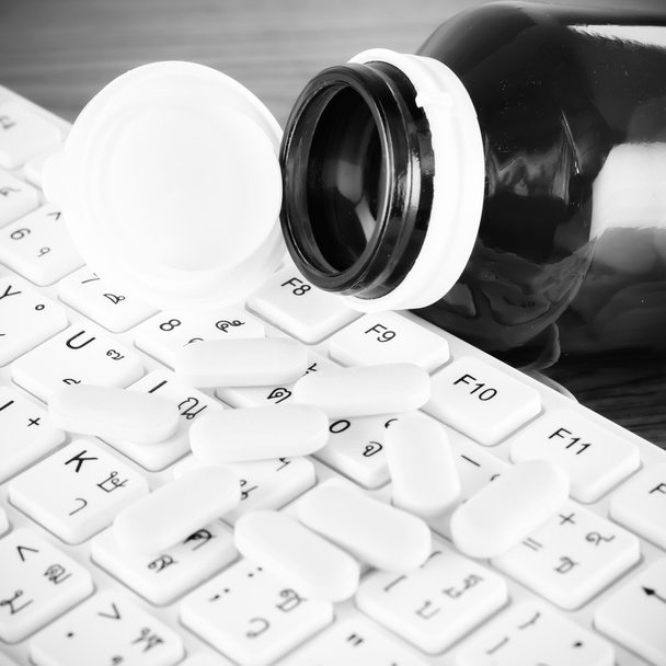 tabletki na klawiaturze komputera czarno-biały kolor dźwięk stylu - Zdjęcie, obraz