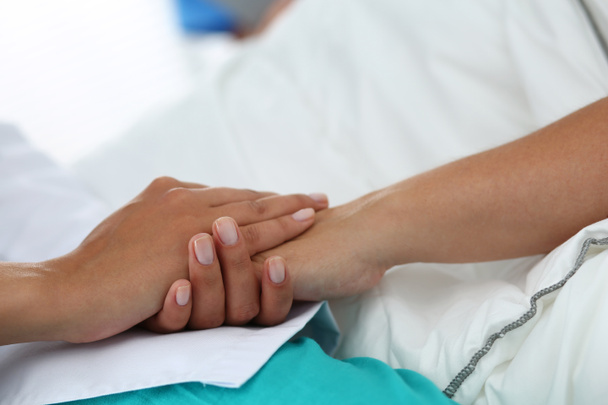 Friendly female doctor hands holding patient hand  - Fotó, kép