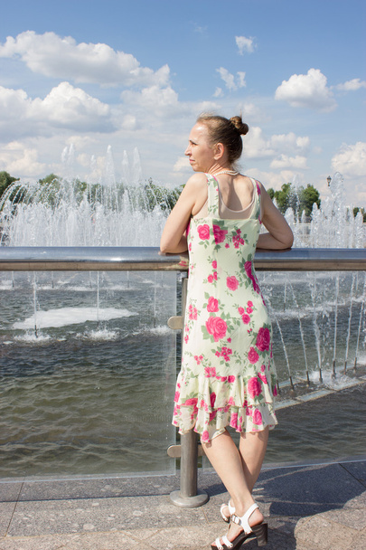 噴水の近くに立っている女性 - 写真・画像