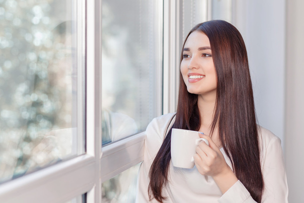 woman drinking tea near  the window - Fotó, kép