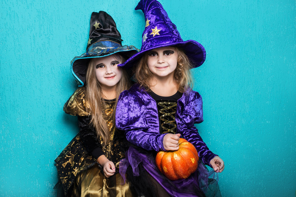Girls in a suit of a witch. Halloween. Fairy. Tale. Studio portrait on blue background - Foto, Imagen