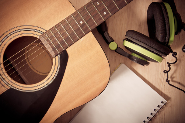 Блокнот і навушники на дерев'яному фоні з гітарою
 - Фото, зображення