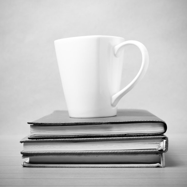 pila de libro con taza de café estilo de tono blanco y negro
 - Foto, imagen